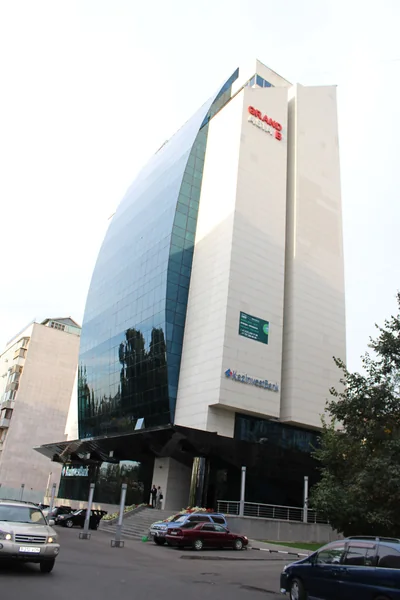 Grand China: Tall commercial building with pale facade and blue glazing viewed from the street