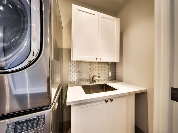 Joicey Boulevard 2: Laundry alcove with stacked machines, sink and wall cabinet