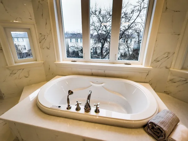 Joicey Boulevard 2: Inset bathtub beneath a large window in a tiled bathroom