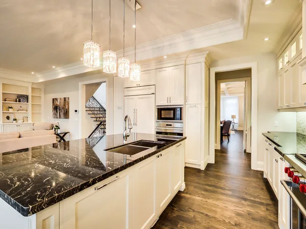 Joicey Boulevard 2: White kitchen cabinetry surrounding a dark stone island