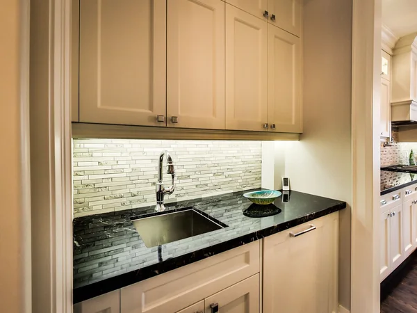 Joicey Boulevard 2: Kitchen sink beneath white wall cabinets and tiled backsplash