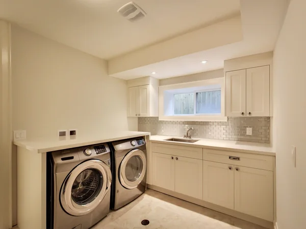 Joicey Boulevard 2: Laundry room with front-loading machines and white cabinets