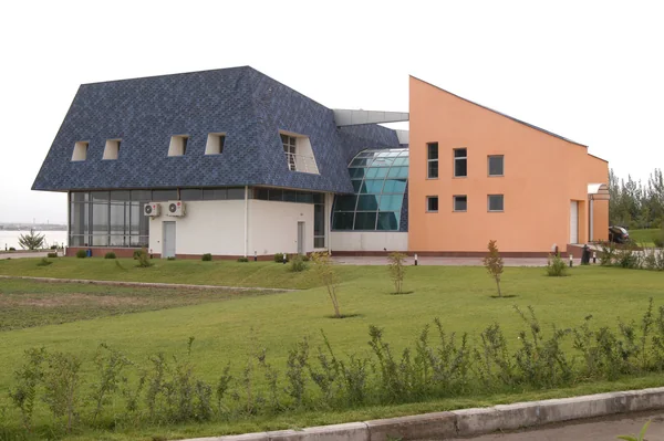 Kazakhstan–Kapchegai: Commercial building exterior with dark pitched roof and orange facade