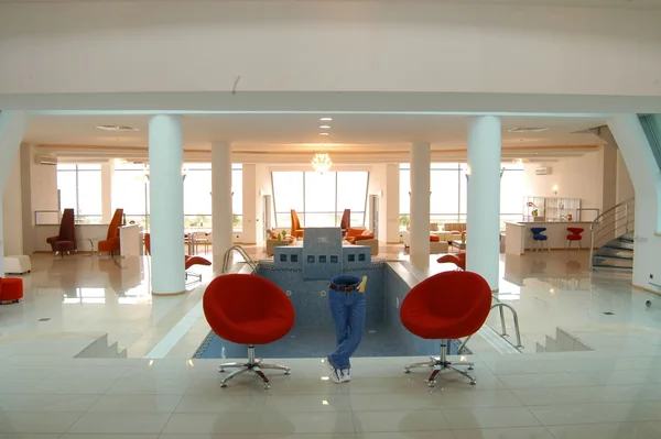 Kazakhstan–Kapchegai: Bright commercial interior with blue table and red chairs