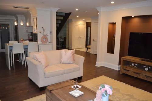 Nevada Avenue: Living area with white armchair and wall-mounted television