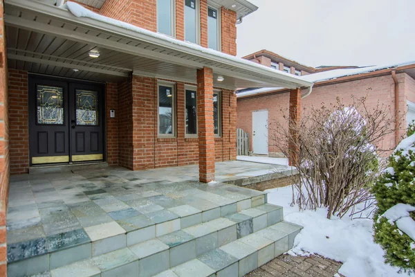Tilman Circle: Covered front entrance with brick columns and broad stone steps