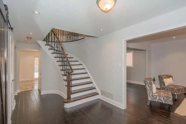 Tilman Circle: Entry hall with curved staircase and dark wood floor