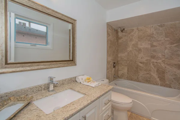 Tilman Circle: Bathroom vanity beside a tiled bathtub