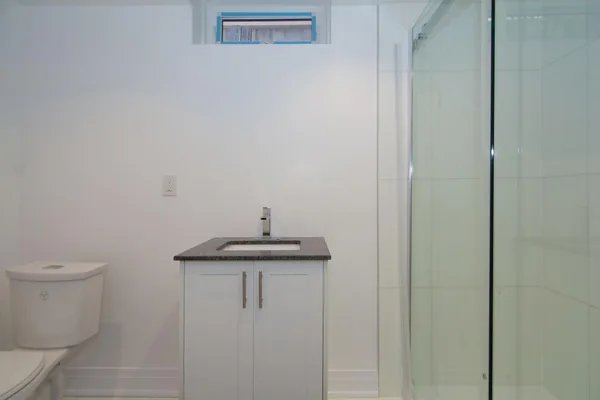 Tilman Circle: Small bathroom with vanity and glass shower enclosure