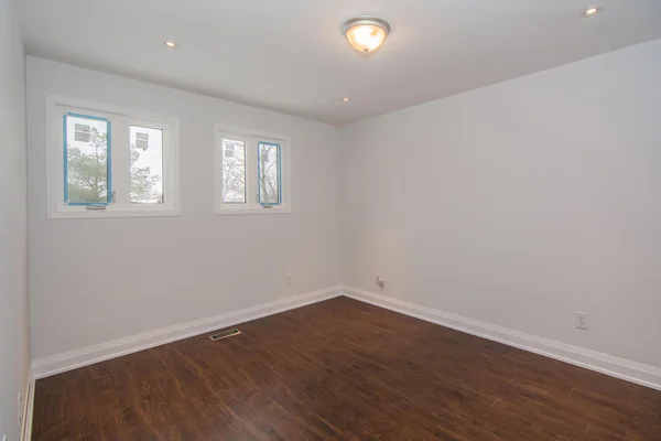 Tilman Circle: Empty room with dark wood floor and three windows